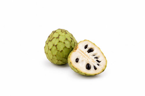 Cherimoya — cały owoc i połówka z białym miąższem